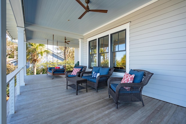 wooden terrace with an outdoor living space, covered porch, and a ceiling fan