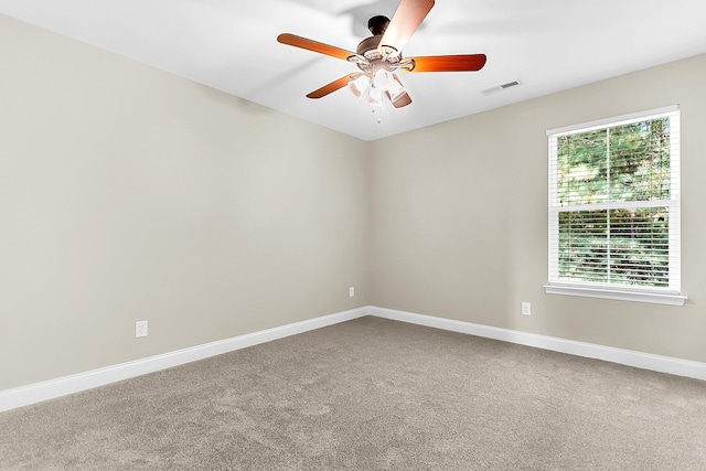 spare room featuring ceiling fan, carpet, and plenty of natural light