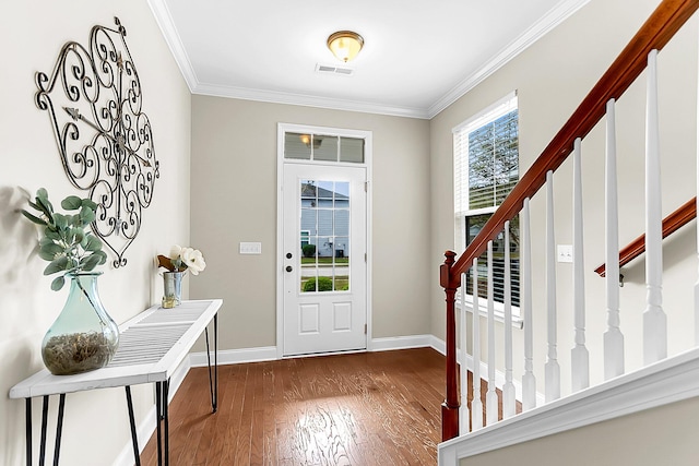 foyer entrance with ornamental molding and dark wood-type flooring