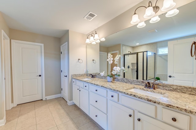 bathroom featuring tile patterned floors, vanity, and a shower with shower door