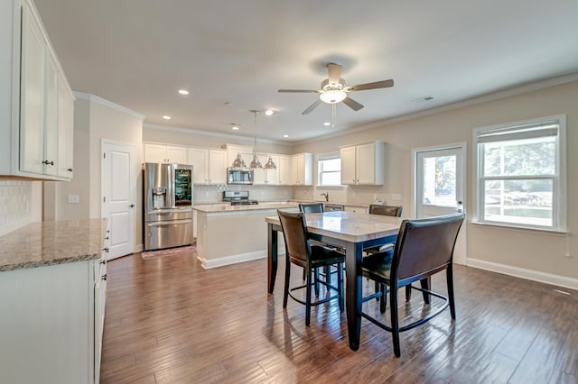 dining space with dark hardwood / wood-style flooring, ceiling fan, and ornamental molding