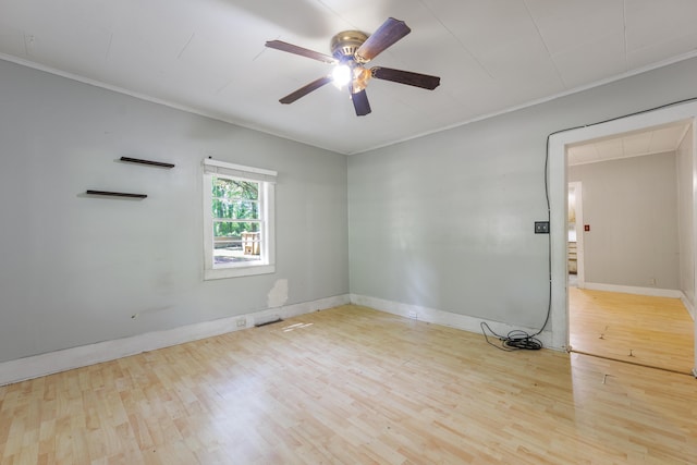 spare room featuring baseboards, ceiling fan, crown molding, and wood finished floors