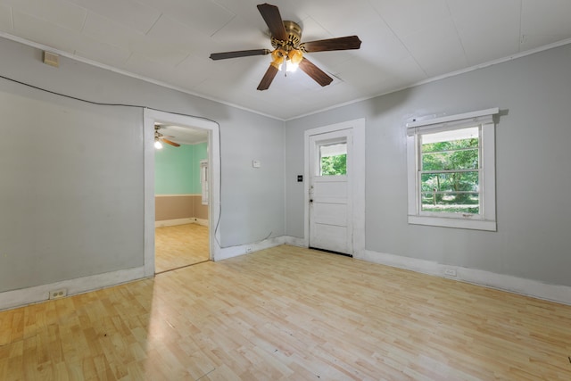 empty room with baseboards, ceiling fan, ornamental molding, and wood finished floors