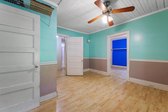 unfurnished bedroom featuring baseboards, ornamental molding, a ceiling fan, and wood finished floors