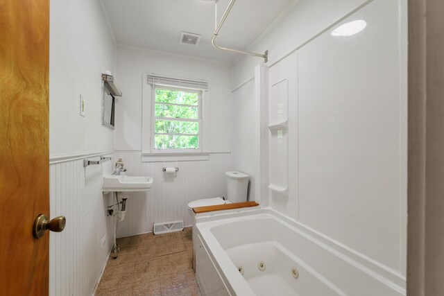full bath featuring toilet, visible vents, and a wainscoted wall