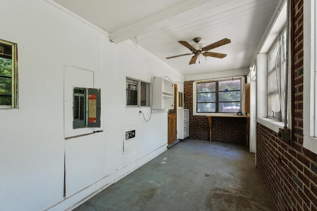 unfurnished sunroom featuring ceiling fan and electric panel