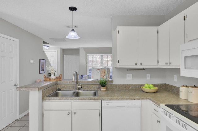 kitchen with sink, hanging light fixtures, kitchen peninsula, white appliances, and white cabinets