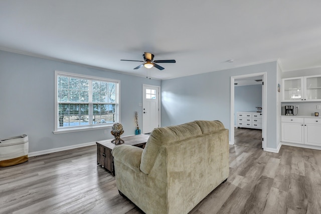 living room featuring ornamental molding, ceiling fan, and light hardwood / wood-style floors