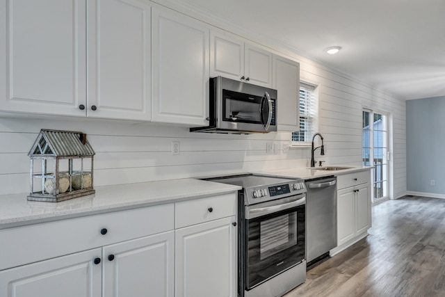 kitchen with white cabinetry, appliances with stainless steel finishes, sink, and light wood-type flooring