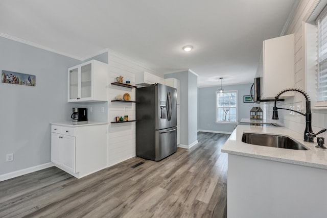 kitchen with pendant lighting, sink, white cabinetry, stainless steel appliances, and light stone counters