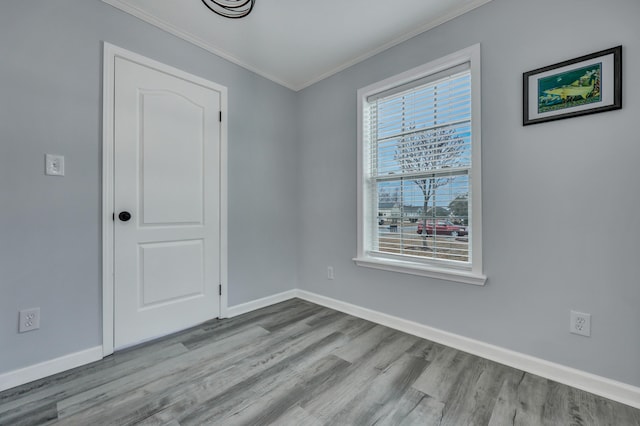 empty room featuring ornamental molding and light wood-type flooring