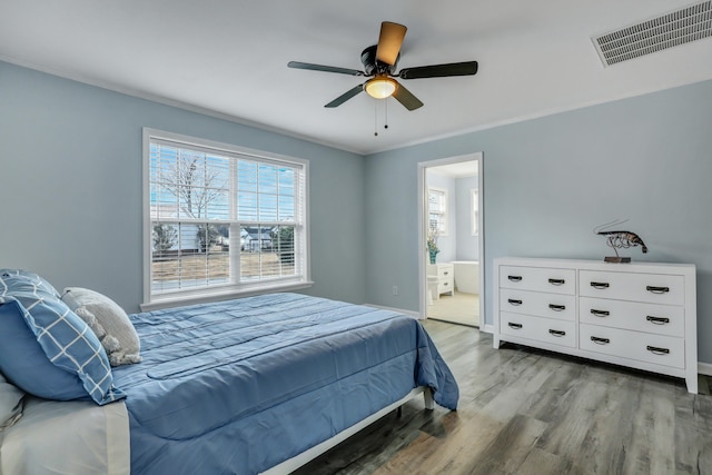 bedroom with ceiling fan, connected bathroom, and light wood-type flooring