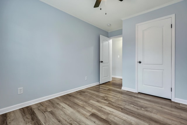 unfurnished bedroom featuring ceiling fan, ornamental molding, and light wood-type flooring