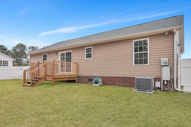 back of property with a wooden deck, central AC, and a lawn