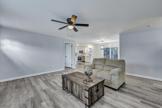 living room featuring ceiling fan and light wood-type flooring