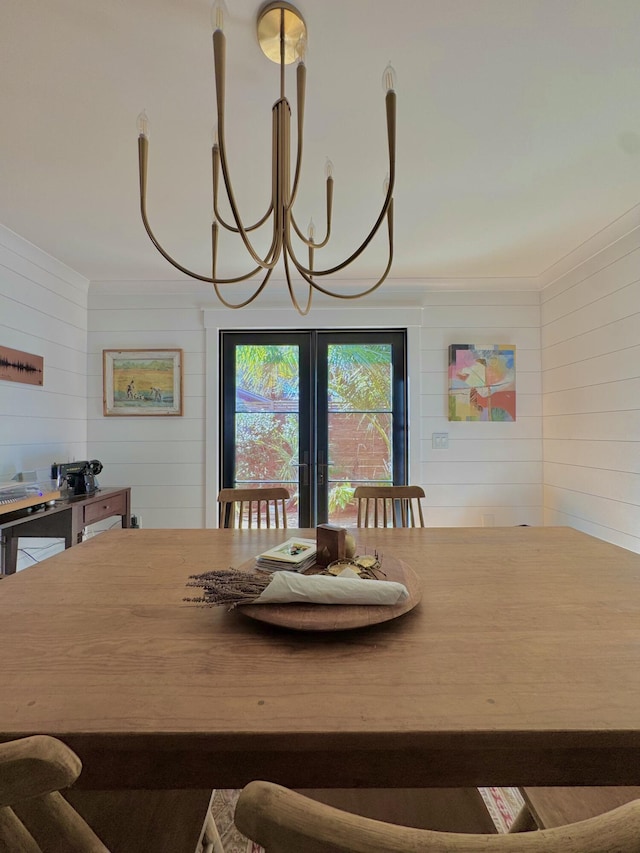 dining room featuring french doors and wooden walls