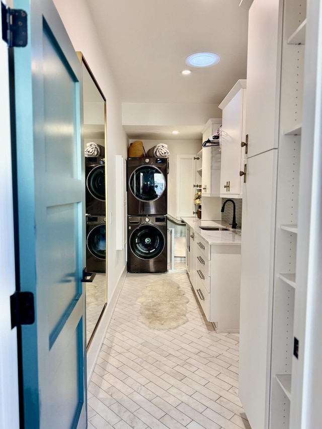 laundry area featuring sink and stacked washer / drying machine