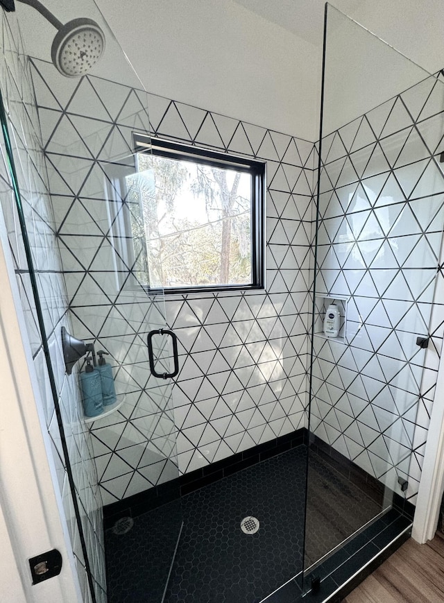 bathroom featuring hardwood / wood-style flooring and walk in shower