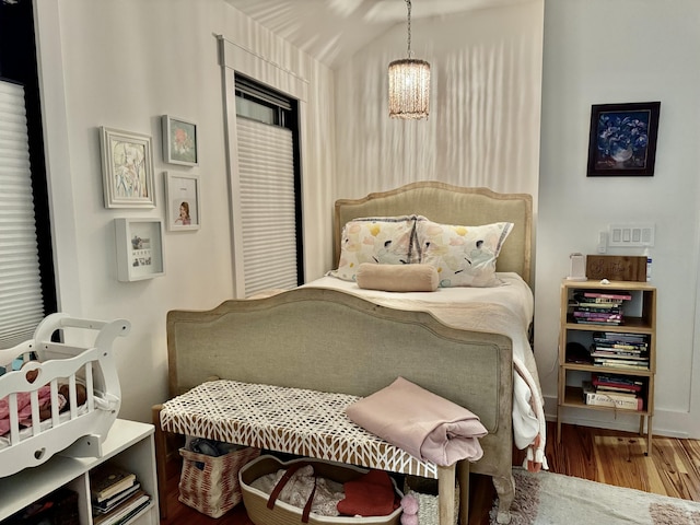 bedroom featuring an inviting chandelier and hardwood / wood-style floors