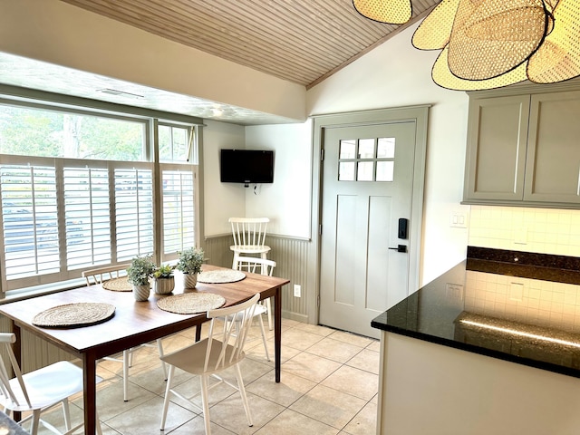 tiled dining space with vaulted ceiling and wood ceiling