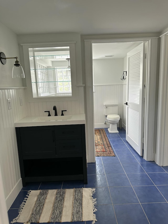 bathroom featuring toilet, vanity, and tile patterned flooring