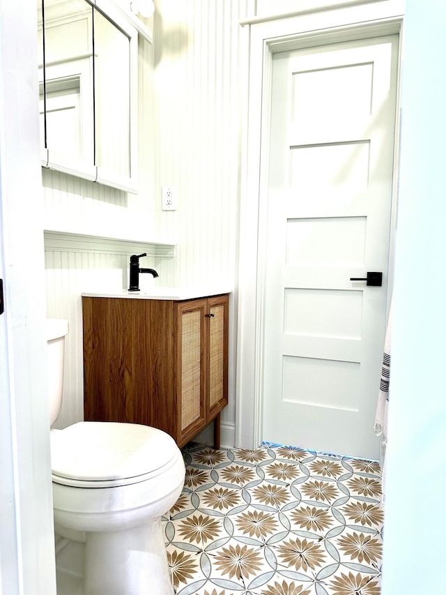 bathroom featuring toilet, vanity, and tile patterned flooring