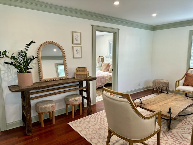 sitting room with dark wood-type flooring and ornamental molding