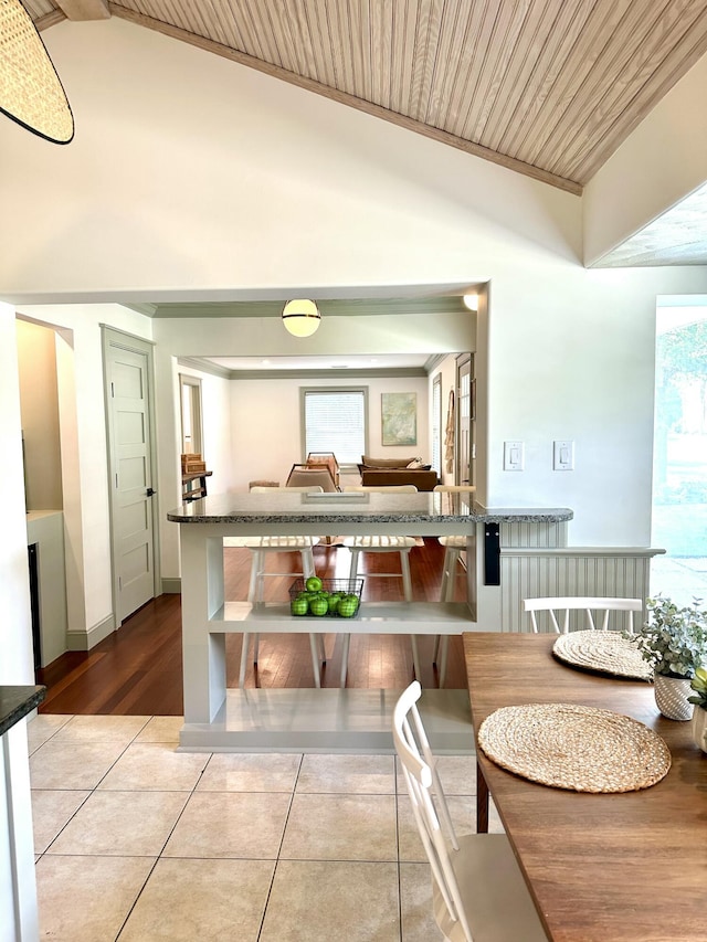 tiled dining area with wooden ceiling and lofted ceiling