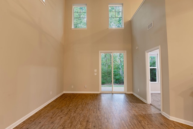 5001 Hay Bale Ct, Summerville, SC 29485 - unfurnished living room featuring a towering ceiling, wood finished floors, and baseboards