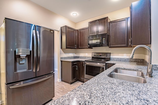 5001 Hay Bale Ct, Summerville, SC 29485 - kitchen featuring appliances with stainless steel finishes, a sink, dark brown cabinets, light wood-style flooring, and light stone counters