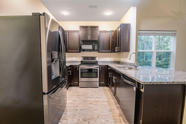 5001 Hay Bale Ct, Summerville, SC 29485 - kitchen featuring black appliances, a sink, light stone countertops, light wood-type flooring, and dark brown cabinetry