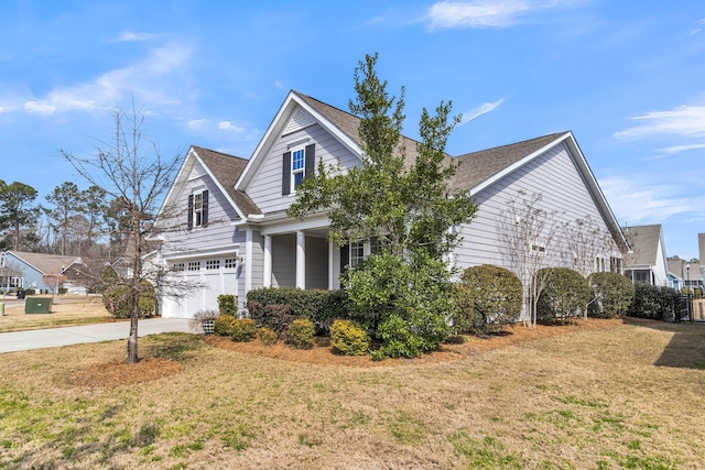 view of side of home with driveway, a lawn, and an attached garage