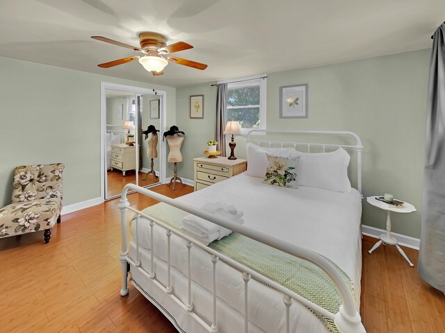 bedroom featuring light wood-style flooring, baseboards, a ceiling fan, and a closet