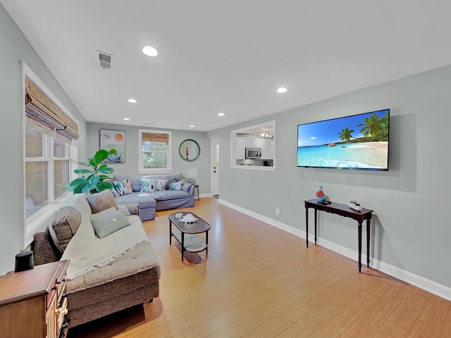 living area featuring light wood finished floors, baseboards, and recessed lighting