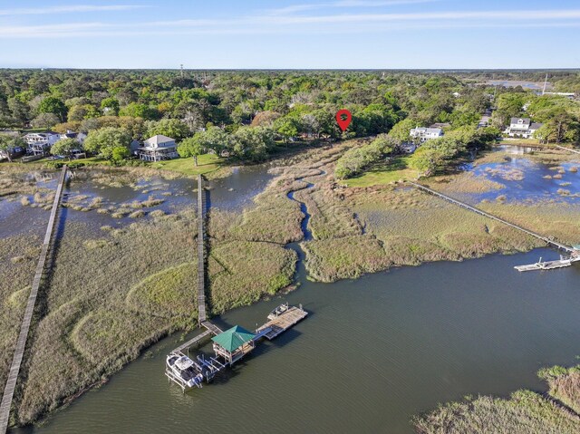 aerial view of property's location with a forest and a nearby body of water