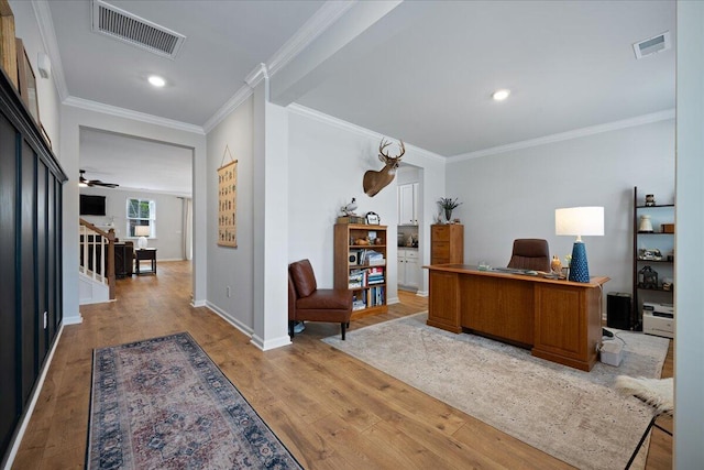 office space featuring visible vents, baseboards, light wood-style flooring, and crown molding