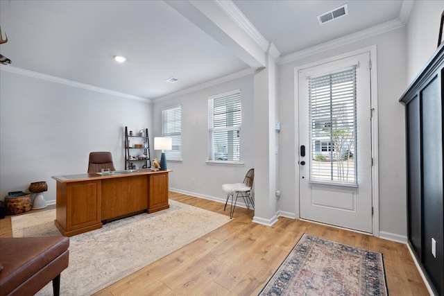 home office with light wood-style flooring, visible vents, and a wealth of natural light