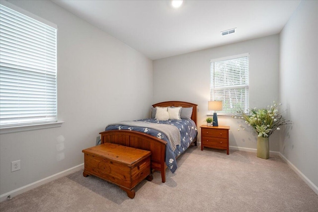 bedroom featuring visible vents, baseboards, and light colored carpet