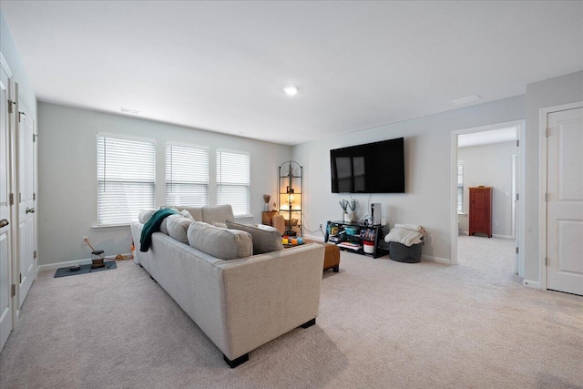 carpeted living room featuring baseboards