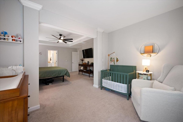 carpeted bedroom with a ceiling fan, a tray ceiling, and baseboards