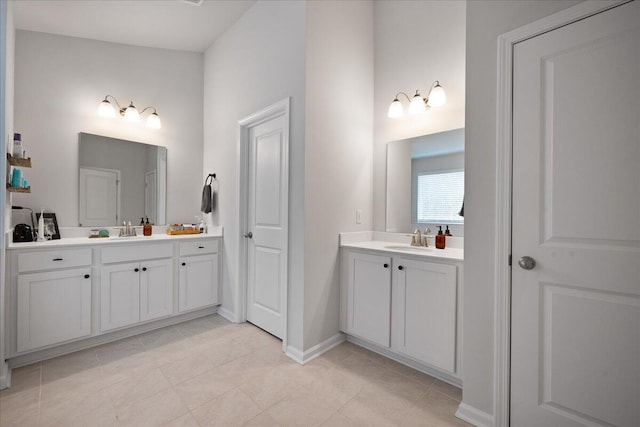 bathroom with a sink, baseboards, and two vanities