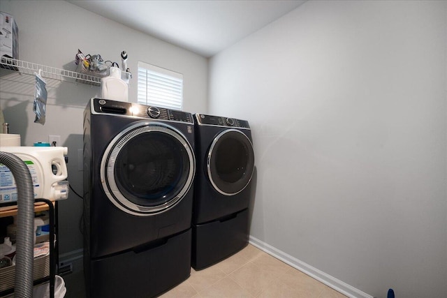 washroom with laundry area, baseboards, and washer and clothes dryer