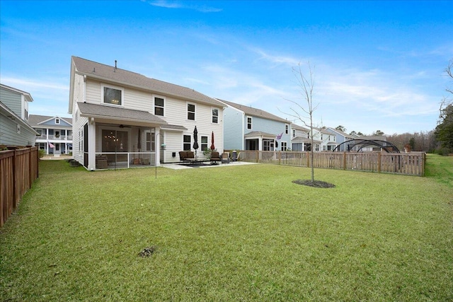 back of property featuring a yard, a patio, a fenced backyard, and a sunroom