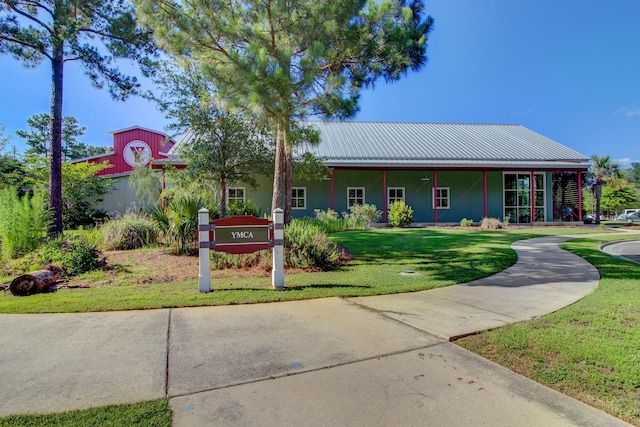 view of front of property featuring a front yard and metal roof