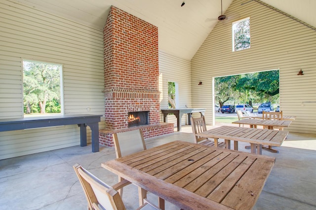 view of patio featuring outdoor dining area and an outdoor brick fireplace