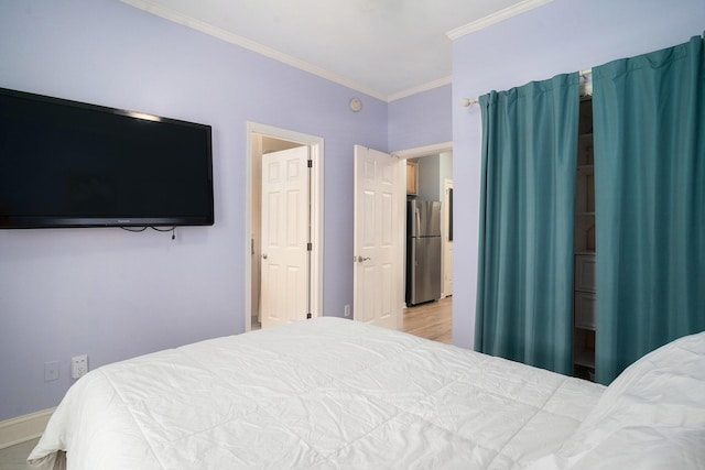 bedroom featuring stainless steel refrigerator and crown molding