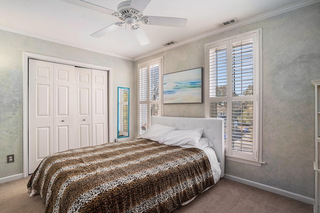 carpeted bedroom featuring crown molding, ceiling fan, and a closet