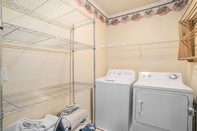 laundry area with ornamental molding and washer and dryer