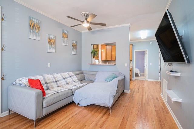 living room featuring crown molding, ceiling fan, and light wood-type flooring