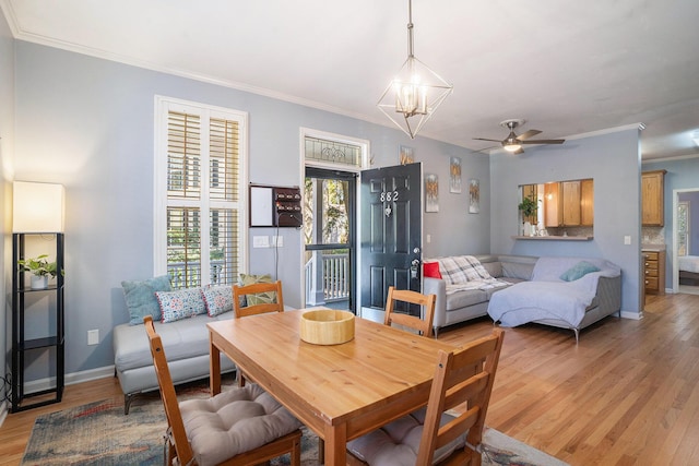 dining area featuring ornamental molding, ceiling fan with notable chandelier, and light hardwood / wood-style floors